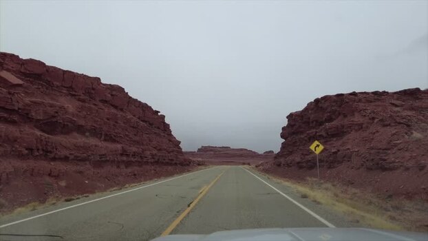 View of a desert road with distant rock formations United States. View of a desert road with distant rock formations United States.
