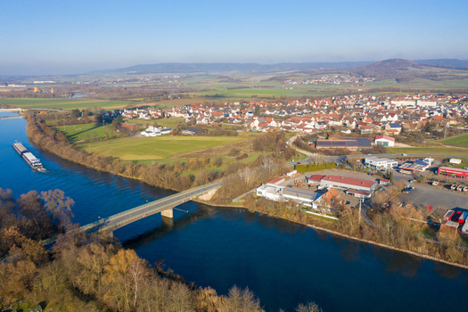 Aerial view of Liapor GmbH Co. KG industrial facility a bridge over the river with a cargo barge and the town of Hallerndorf Bayern Germany. Aerial view of Liapor GmbH Co. KG industrial facility a bridge over the river with a cargo barge and the town of Hallerndorf Bayern Germany.