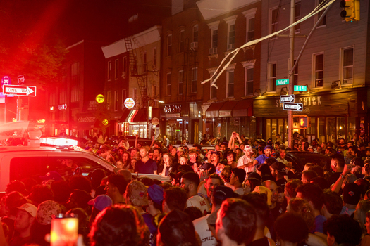 Williamsburg Brooklyn New York USA 14 June 2026 View of crowds celebrating in the street at night with red emergency lights illuminating the urban architecture. Williamsburg Brooklyn New York USA 14 June 2026 View of crowds celebrating in the street at night with red emergency lights illuminating the urban architecture.