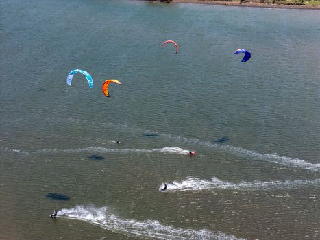 Aerial view of kitesurfers gliding across the water with colorful kites at Depok Beach Special Region of Yogyakarta Indonesia.