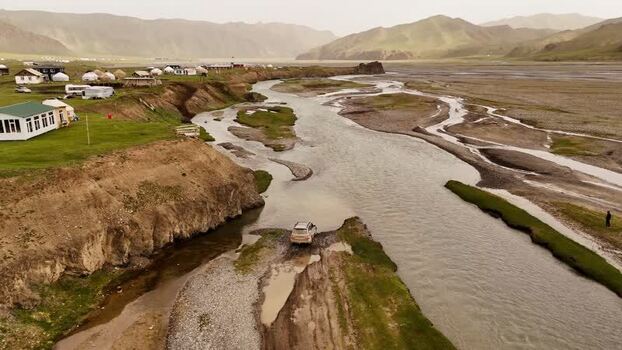 Aerial view of vehicle crossing river in Kok Kiya Valley Kyrgyzstan. Aerial view of vehicle crossing river in Kok Kiya Valley Kyrgyzstan.
