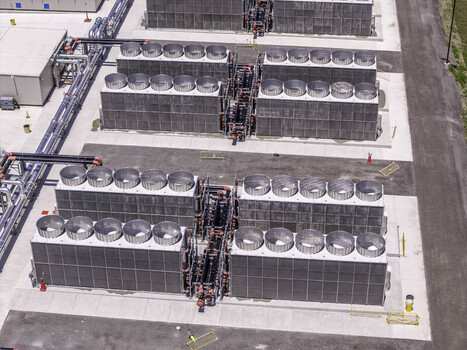 Aerial view of data center cooling infrastructure with large industrial fans and piping systems on a concrete pad in Gallatin Tennessee United States. Aerial view of data center cooling infrastructure with large industrial fans and piping systems on a concrete pad in Gallatin Tennessee United States.