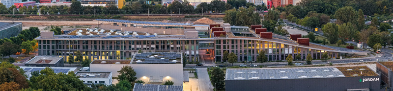 Aerial view of the Curve Campus tech and business hub in Adlershof with its modern architecture green roof and solar panels surrounded by trees in Berlin Berlin Germany. Aerial view of the Curve Campus tech and business hub in Adlershof with its modern architecture green roof and solar panels surrounded by trees in Berlin Berlin Germany.
