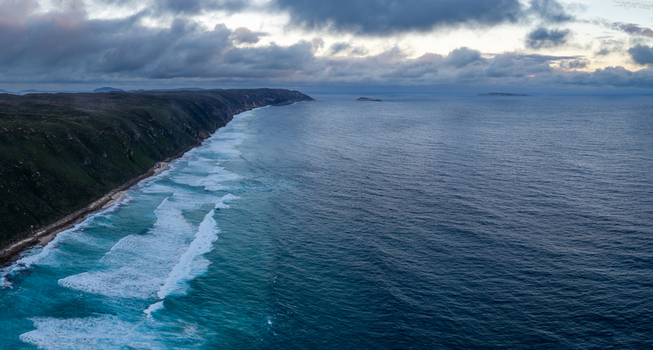 Aerial view of the rugged Sandpatch coastline with dramatic cliffs turquoise waves and a cloudy sky over the Southern Ocean in Albany Western Australia Australia. Aerial view of the rugged Sandpatch coastline with dramatic cliffs turquoise waves and a cloudy sky over the Southern Ocean in Albany Western Australia Australia.