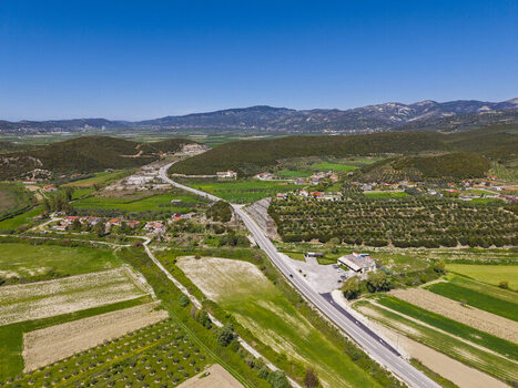 Aerial view of the rural landscape near Lushnje featuring a road cutting through agricultural fields olive groves and rolling hills. Lushnje Fier County Albania. Aerial view of the rural landscape near Lushnje featuring a road cutting through agricultural fields olive groves and rolling hills. Lushnje Fier County Albania.