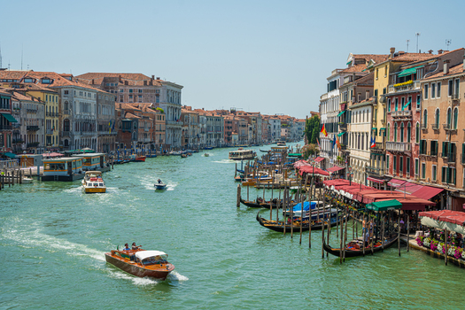Venice Italy 29 March 2026 View of the Grand Canal shimmering under a bright sky with gondolas and boats navigating past historic buildings and vibrant waterfront cafes. Venice Italy 29 March 2026 View of the Grand Canal shimmering under a bright sky with gondolas and boats navigating past historic buildings and vibrant waterfront cafes.