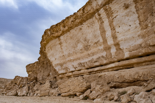 View of majestic cliffs rise with striated layers of earth tones against the backdrop of a soft overcast sky highlighting the stark beauty Cairo Cairo Governorate Egypt. View of majestic cliffs rise with striated layers of earth tones against the backdrop of a soft overcast sky highlighting the stark beauty Cairo Cairo Governorate Egypt.