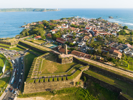 Aerial view of the historic Galle Fort and clock tower with colonial buildings and stone ramparts overlooking the ocean in Galle Southern Province Sri Lanka.