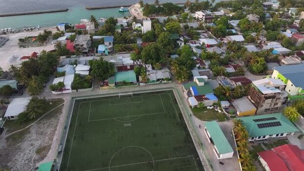 Aerial view of a soccer field and coastal village houses Maldives. Aerial view of a soccer field and coastal village houses Maldives.