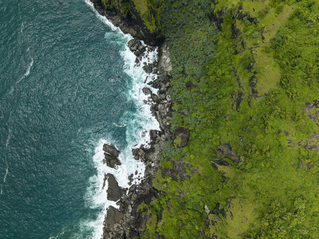 Aerial view of the rugged Pengilon Hill coastline where emerald green cliffs meet the turquoise ocean Gunungkidul Regency Daerah Istimewa Yogyakarta Indonesia. Aerial view of the rugged Pengilon Hill coastline where emerald green cliffs meet the turquoise ocean Gunungkidul Regency Daerah Istimewa Yogyakarta Indonesia.