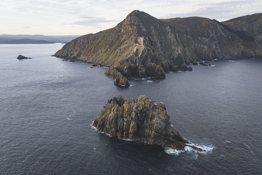 Aerial view of the dramatic rocky cliffs and rugged coastline of Cabo Ortegal surrounded by the deep blue Atlantic Ocean in Galicia Spain.