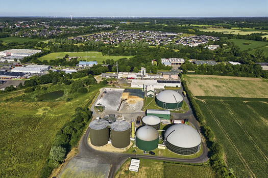 Schleswig Schleswig Holstein Germany 26 June 2026 Aerial view of a biogas plant with large circular tanks and industrial buildings surrounded by green fields and residential areas. Schleswig Schleswig Holstein Germany 26 June 2026 Aerial view of a biogas plant with large circular tanks and industrial buildings surrounded by green fields and residential areas.