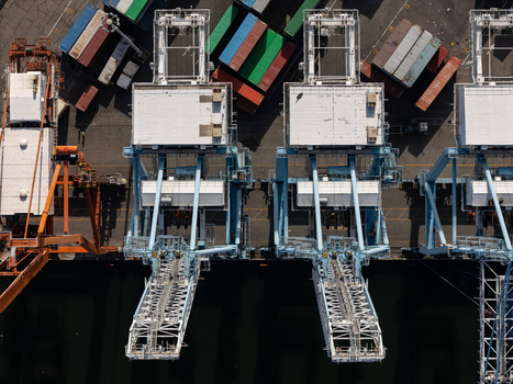 Aerial view of large container cranes and colorful shipping containers at the industrial port in Bajos de Haina San Cristobal Provinc Dominican Republic.