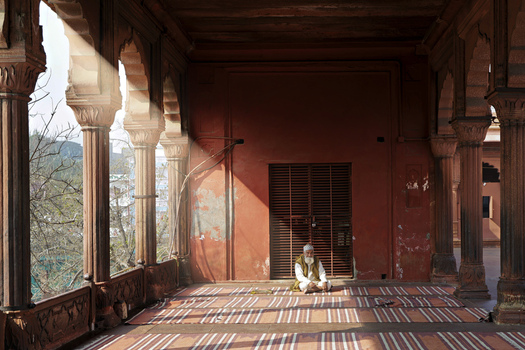 Delhi India 11 February 2026 View of a man meditating in the serene sun drenched colonnades of Jama Masjid where light and shadow dance across the patterned floor. Delhi India 11 February 2026 View of a man meditating in the serene sun drenched colonnades of Jama Masjid where light and shadow dance across the patterned floor.
