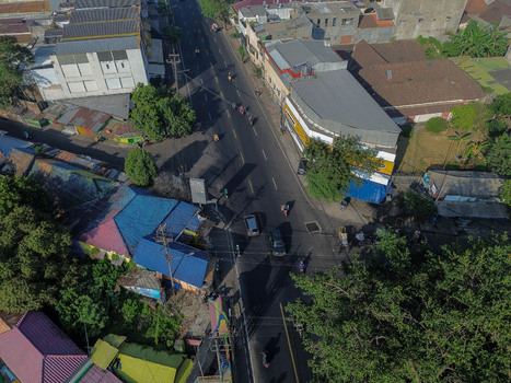 Aerial view of Kampung Warna Warni Jodipan with its vibrant colorful rooftops busy street intersection and lush trees in Kecamatan Blimbing Jawa Timur Indonesia. Aerial view of Kampung Warna Warni Jodipan with its vibrant colorful rooftops busy street intersection and lush trees in Kecamatan Blimbing Jawa Timur Indonesia.