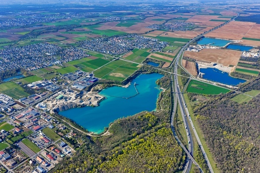 Aerial view of turquoise waters meet the industrial landscape and verdant fields Sausheim Grand Est France.