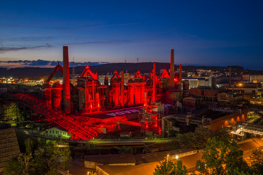 Volklingen Germany 09 May 2026 Aerial view of Volklingen Ironworks illuminated with red lights at dusk against a deep blue twilight sky. Volklingen Germany 09 May 2026 Aerial view of Volklingen Ironworks illuminated with red lights at dusk against a deep blue twilight sky.