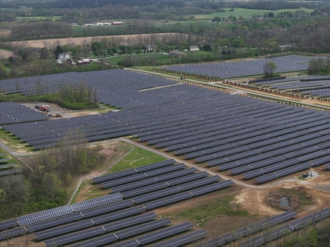 Lebanon United States 12 April 2026 Aerial view of a large solar farm with rows of photovoltaic panels stretching across the landscape surrounded by green fields and trees.