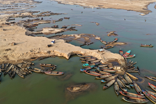 Aerial view of Jadukata River with numerous wooden boats moored along the sandy riverbanks in Sunamganj Sylhet Division Bangladesh. Aerial view of Jadukata River with numerous wooden boats moored along the sandy riverbanks in Sunamganj Sylhet Division Bangladesh.
