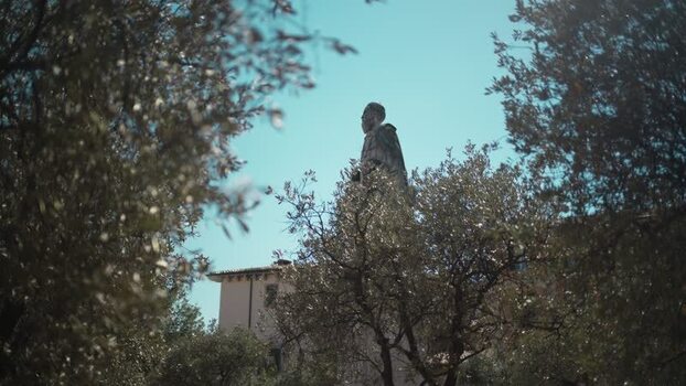 View of the Dante Alighieri statue through olive trees Italy. View of the Dante Alighieri statue through olive trees Italy.