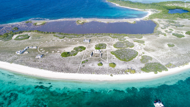 Aerial view of Los Roques archipelago with white sand beaches turquoise waters a central lagoon and sparse vegetation in Los Roques Dependencias Federales Venezuela. Aerial view of Los Roques archipelago with white sand beaches turquoise waters a central lagoon and sparse vegetation in Los Roques Dependencias Federales Venezuela.