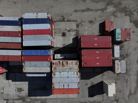 Aerial view of stacked shipping containers in a logistics terminal with long shadows on the concrete ground Cincinnati OH United States.