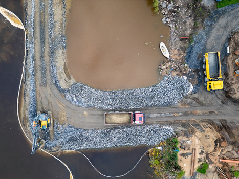 Oulu North Ostrobothnia Finland 18 September 2026 Aerial view of the construction site at the waterfront with heavy machinery including a dump truck and excavator working on the rocky shoreline. Oulu North Ostrobothnia Finland 18 September 2026 Aerial view of the construction site at the waterfront with heavy machinery including a dump truck and excavator working on the rocky shoreline.