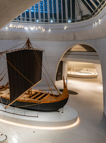 Abu Dhabi United Arab Emirates 03 August 2026 View of a traditional wooden dhow boat displayed inside the modern curved white interior of the Zayed National Museum.