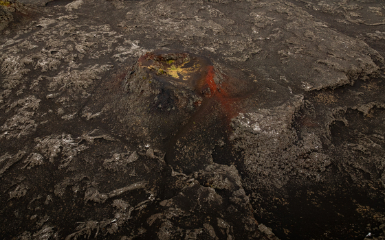 Aerial view of a volcanic crater surrounded by rugged black lava fields in Reykjanesbaer Iceland.