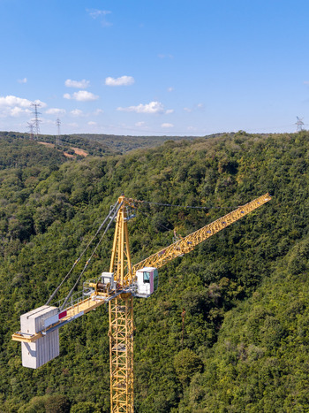 Aerial view of a yellow construction crane standing amidst a dense green forest under a clear blue sky in Istanbul Istanbul Turkiye. Aerial view of a yellow construction crane standing amidst a dense green forest under a clear blue sky in Istanbul Istanbul Turkiye.