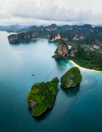 Aerial view of Railay Beach with dramatic limestone cliffs lush tropical vegetation and turquoise waters Ao Nang Krabi Thailand. Aerial view of Railay Beach with dramatic limestone cliffs lush tropical vegetation and turquoise waters Ao Nang Krabi Thailand.
