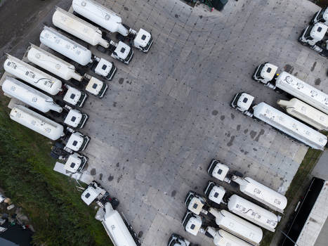 Aerial view of a parking lot filled with white tanker trucks arranged in rows on a paved surface in Krakow Lesser Poland Voivode Poland.