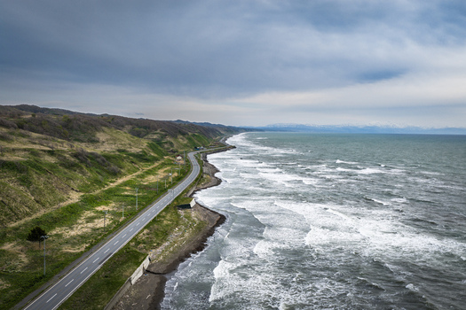 Aerial view of the coastal road winding along the rugged cliffs and the Sea of Okhotsk in Wakkanai Hokkaido Japan.