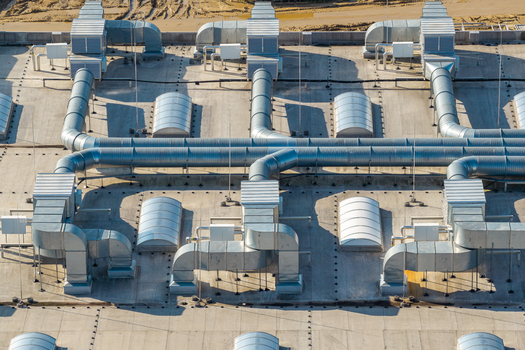 Aerial view of an advanced motorboat production facility roof featuring extensive metal ventilation ducting and skylights in Poland.