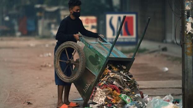 View of a man emptying a garbage cart in Bogura Bangladesh. View of a man emptying a garbage cart in Bogura Bangladesh.