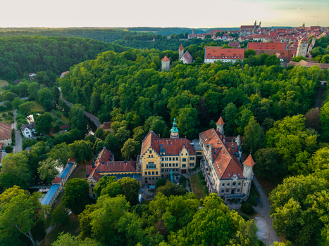 Aerial view of the historic buildings and lush green forests surrounding the town of Rothenburg ob der Tauber Bavaria Germany. Aerial view of the historic buildings and lush green forests surrounding the town of Rothenburg ob der Tauber Bavaria Germany.