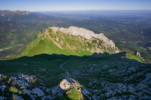 View of the rocky peak of Zdiarska vidla in the Belianske Tatry mountains with green slopes and a distant valley under a clear blue sky Zdiar Presov Region Slovakia. View of the rocky peak of Zdiarska vidla in the Belianske Tatry mountains with green slopes and a distant valley under a clear blue sky Zdiar Presov Region Slovakia.