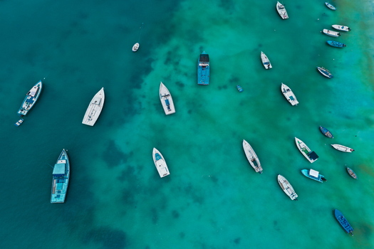 Aerial view of numerous small boats floating in the clear turquoise waters of the Indian Ocean Kulhudhuffushi Haa Dhaalu Atoll Maldives. Aerial view of numerous small boats floating in the clear turquoise waters of the Indian Ocean Kulhudhuffushi Haa Dhaalu Atoll Maldives.