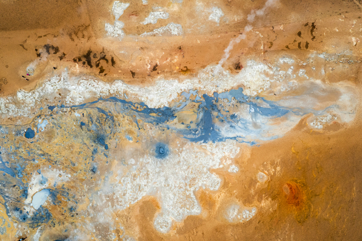 Aerial view of Hverir geothermal area with steaming vents bubbling mud pools and colorful mineral deposits in Reykjahlid THingeyjarsveit Iceland.