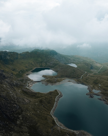 Aerial view of the mountainous landscape of Snowdon featuring glacial lakes and winding paths in Caernarfon Wales United Kingdom.