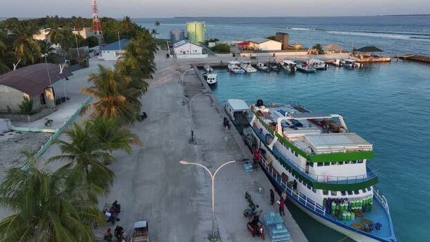 Aerial view of a cargo boat docked at a harbor with people Maldives. Aerial view of a cargo boat docked at a harbor with people Maldives.
