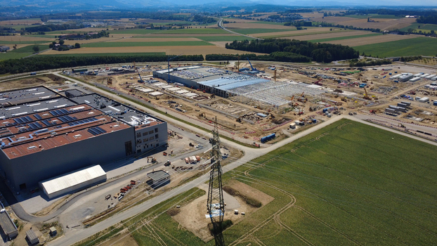 Aerial view of a data center construction site with large industrial buildings heavy machinery and surrounding agricultural fields in Kronstorf Upper Austria Austria. Aerial view of a data center construction site with large industrial buildings heavy machinery and surrounding agricultural fields in Kronstorf Upper Austria Austria.