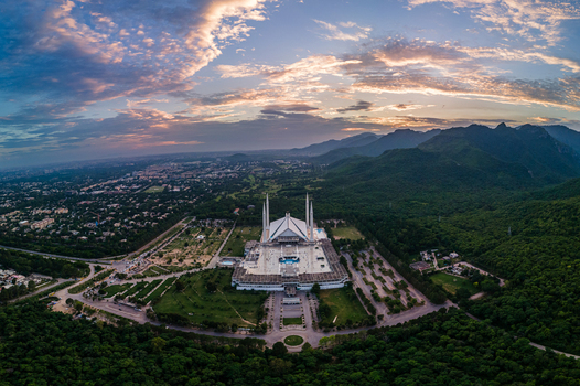 Aerial view of Faisal Masjid nestled at the foot of the Margalla Hills with its iconic white marble architecture under a vibrant sunset sky Islamabad Islamabad Capital Ter Pakistan. Aerial view of Faisal Masjid nestled at the foot of the Margalla Hills with its iconic white marble architecture under a vibrant sunset sky Islamabad Islamabad Capital Ter Pakistan.