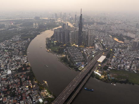 Aerial view of Landmark 81 skyscraper and the Saigon River winding through the urban skyline at twilight in Ho Chi Minh City Ho Chi Minh Vietnam. Aerial view of Landmark 81 skyscraper and the Saigon River winding through the urban skyline at twilight in Ho Chi Minh City Ho Chi Minh Vietnam.