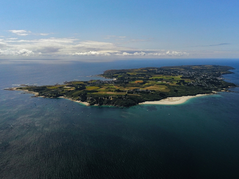 Aerial view of the island of Ile de Brehat with its lush green fields sandy beaches and rocky coastline surrounded by the blue sea in Ile de Brehat Brittany France.