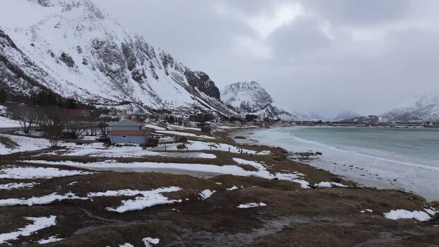 Aerial view of Lofoten mountains and snowy coastline Norway.