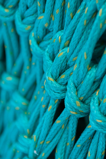 View of a textured teal fishing net with yellow flecks in Canada. View of a textured teal fishing net with yellow flecks in Canada.