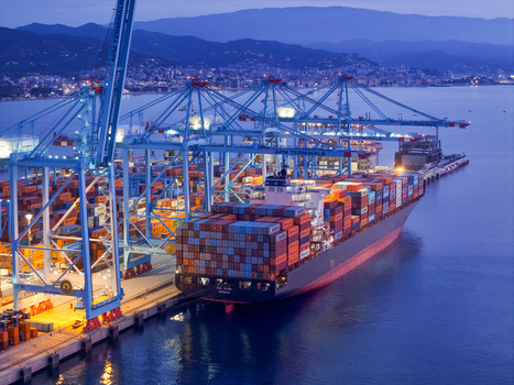 Aerial view of APM Terminals Vado Ligure container port with a large cargo ship docked colorful shipping containers and tall gantry cranes at dusk in Vado Ligure Liguria Italy. Aerial view of APM Terminals Vado Ligure container port with a large cargo ship docked colorful shipping containers and tall gantry cranes at dusk in Vado Ligure Liguria Italy.