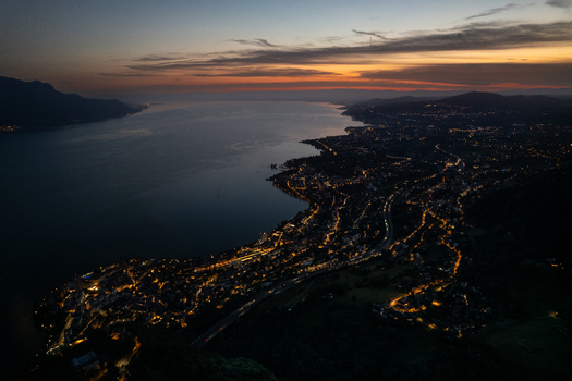 Aerial view of Glion and the illuminated coastline of Montreux along Lake Geneva at twilight with mountains in the background Montreux Vaud Switzerland. Aerial view of Glion and the illuminated coastline of Montreux along Lake Geneva at twilight with mountains in the background Montreux Vaud Switzerland.