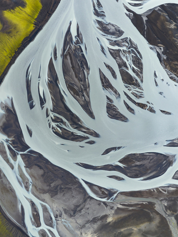 Aerial view of glacial rivers carving through the volcanic landscape creating a mesmerizing dance of white against the dark earth Highlands Iceland.